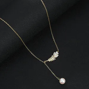 Collier élégant plaqué or avec pendentif plume en nacre et breloque en perle