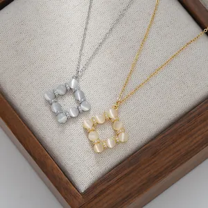 Close-up of gold and silver square cat eye stone pendants with micro-pave zircon detail