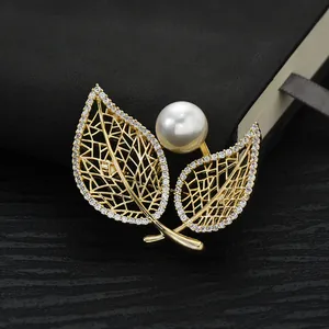 Elegant gold plated leaf brooch with micro-pave zircons and a large white pearl