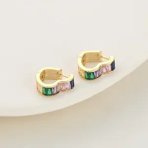 Elegantes pendientes de corazón dorados con circonitas arcoíris en soporte blanco mujer