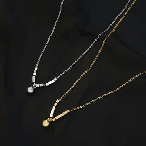 Detailweergave van goud en zilver vergulde minimalistische kettingen met metalen bollen