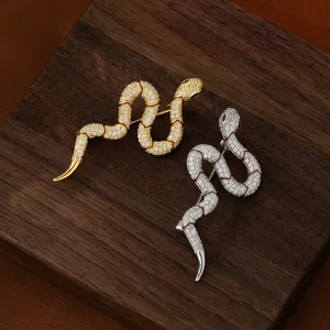 Serpent brooch set in gold and silver finish with sparkling zircons and green stone eyes