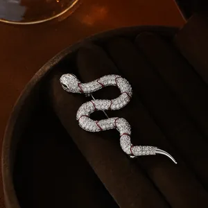Macro detail of a snake brooch with silver plating, zircon pavé, and enamel snake scales