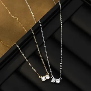 Detailed close-up of delicate gold and silver O-chain necklaces with twin zircon pendants