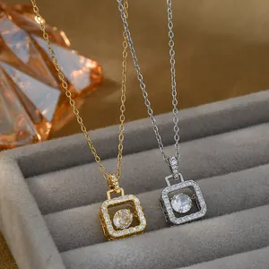 Macro shot of gold and silver square necklaces with dancing center stones and pave zircons