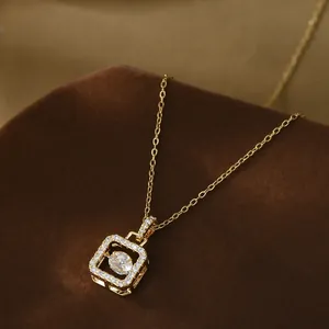 Macro detail of dancing zircon stone within square gold geometric pendant necklace