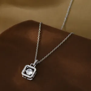 Close-up of gold-plated square pendant with sparkling cubic zirconia on a velvet base