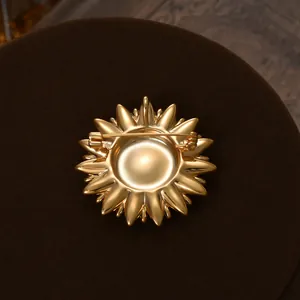 Detailed back view of gold-plated sunflower brooch with secure rotating safety pin clasp