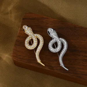 Detailed close-up of gold and silver snake brooches with pave-set sparkling crystals