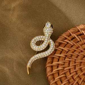 Detailed macro view of gold snake brooch with pavé cubic zirconia and black eyes