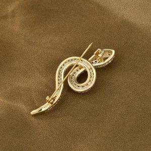 Elegant gold plated snake brooch with sparkling zircons on a dark textured background