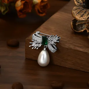 Elegant silver bow brooch with emerald green gemstone and water drop pearl pendant