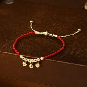 Bracciale tradizionale in corda rossa intrecciata con campane dorate e perle su legno
