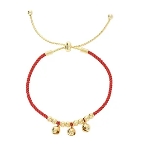 Bracciale in corda rossa intrecciata con tre campanelli dorati e chiusura in metallo regolabile