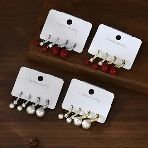 Detailed set of four pairs of elegant pearl and rhinestone earrings on display cards