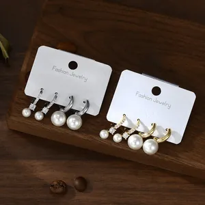 French retro pearl earring set including silver and gold hoops and studs on display card