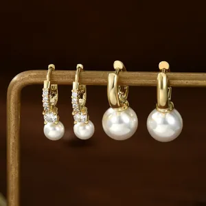 Elegant gold pearl earring set featuring pavé zircon hoops and minimalist wide gold bands