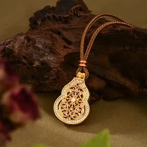 Detalle del colgante de calabaza en filigrana de oro con diamantes sobre madera oscura