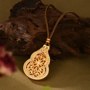 Macro de un colgante de calabaza en filigrana de oro con diamantes y cordón tejido