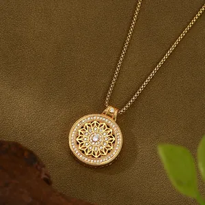 Detalle de un colgante circular de oro con pétalos calados e incrustaciones de circonitas