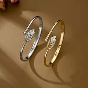 Detailed macro of gold and silver feather bracelets with inlaid zircon stones
