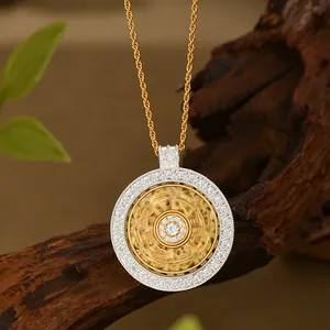Detalle del colgante de oro bicolor con cristales pavé en una cadena de cuerda fina