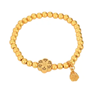 Bracciale tradizionale con perline dorate, ciondolo a fiore e campanello portafortuna
