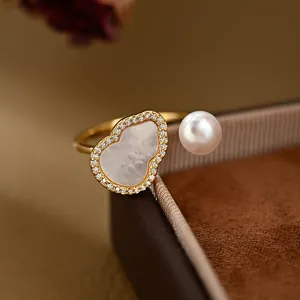 Elegante anello aperto dorato con intarsio in conchiglia a zucca e perla bianca