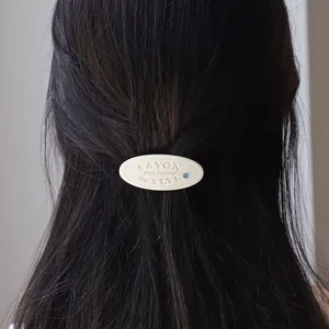Chique crème hars haarklem met blauwe strassteen, gestyled op lang haar voor vrouwen