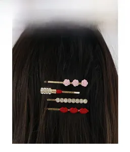 Detailed view of hair clips set featuring red lips, pink flower, and rhinestone lipstick