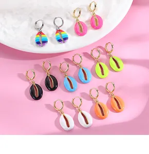 Close-up of vibrant enamel shell pendants and colorful hoops for summer vacation jewelry