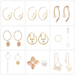 Collection of nine gold-plated earrings with pearls, stars, and geometric charms
