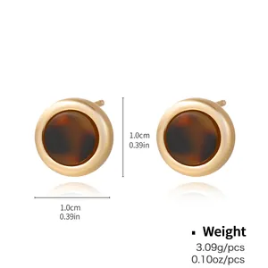 Detail view of gold round stud earrings with tortoise shell resin and size specs