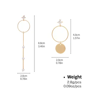 Detail view of asymmetric gold earrings with pearls, hoops, and size specifications