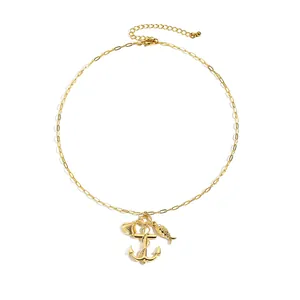 Nautical theme gold necklace with anchor, seashell and fish pendants on white background
