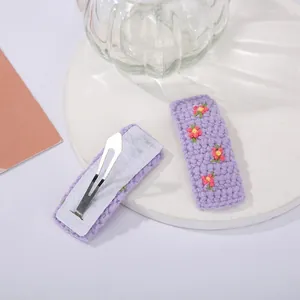 Vue détaillée des barrettes BB tricotées violettes avec broderie florale et pince métal