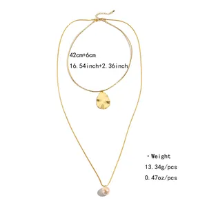 Détails du collier doré double couche avec pendentifs goutte et perle