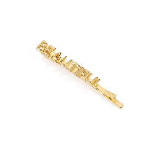Close-up of golden bobby pin with BEAUTIFUL lettering and polished metallic finish