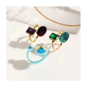 Detailed view of colorful square and drop-shaped crystal rings on a white surface