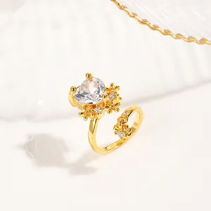 Macro detail of gold-plated nail ring with heart-shaped zircon and floral accent