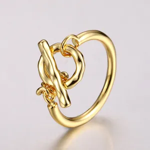 Detail of a polished gold toggle clasp ring with a luxury mirror finish and minimalist design