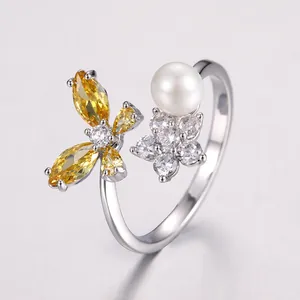 Macro detail of silver adjustable ring with butterfly zircon and white pearl accents
