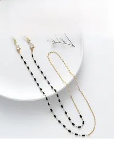 Detail of gold chain and black beads eyewear strap with lobster clasps and rubber loops