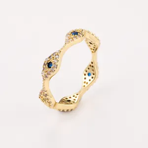 Detailed view of wave-shaped gold ring with blue devil eye motifs and zircon inlays