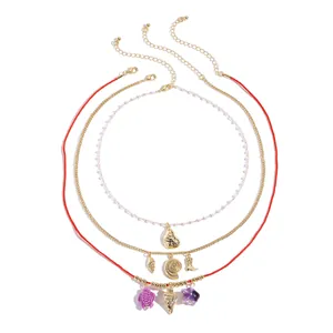 Three-piece ocean themed layered necklace set with gold shell starfish and turtle charms