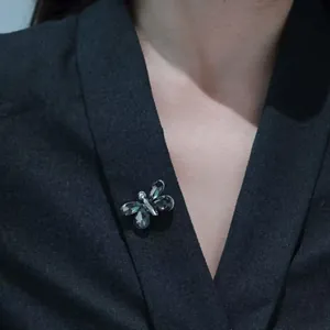 Elegante spilla a farfalla con cristalli grigi scuri su un blazer nero professionale