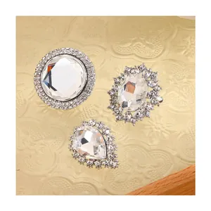 Detail of round, oval and teardrop rhinestone brooches with silver claw-set crystal studs
