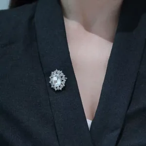Elegant silver brooch with crystal and rhinestones pinned on a formal black blazer lapel