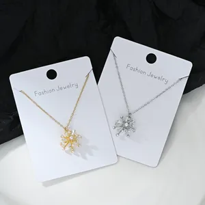 Détails des colliers flocon de neige dorés et argentés avec perles et cristaux baguettes