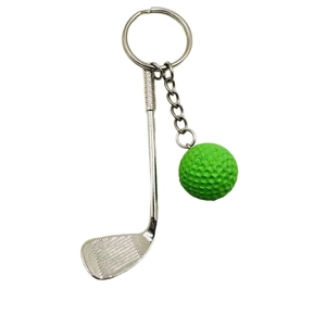 Detail of silver alloy golf club and green ball keychain with textured surface